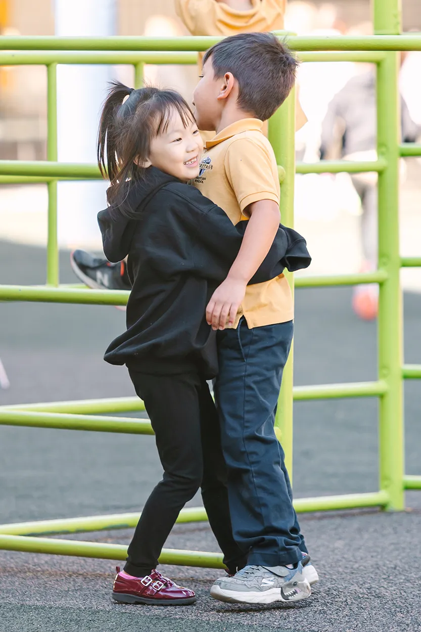 Friends hugging on the playground on our North campus.